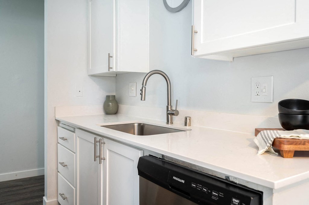 a kitchen with white cabinets and a sink